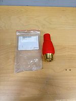 Full view of red Suttner turbo nozzle beside original plastic bag