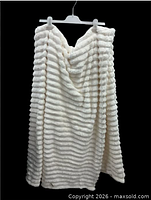 Off-white ribbed plush blanket displayed on hanger to show texture and size