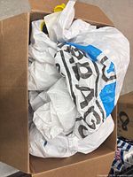 Box containing folded white woven dunnage air bags