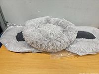 three grey shaggy pet beds stacked