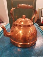 Front view of copper teapot showing spout, handle, lid
