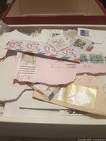 Open box showing mix of stamps on paper fragments.