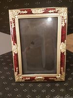 Front view of ornate gold-tone frame with red inset