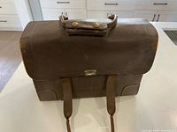 Front view showing brass flip-lock, straps, handle wrap