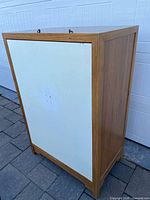 View of cabinet showing white side panel and wood frame