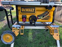 Left side view of DEWALT DW745 table saw on DW7440RS stand showing rack-and-pinion fence, bevel gauge and wheel