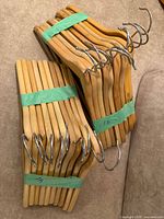 Two bundles of natural wood hangers strapped together