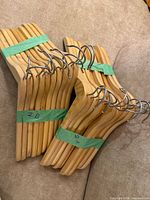 Bundle of natural wood IKEA hangers taped together in two sets