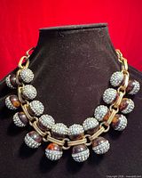 Necklace displayed on bust showing tortoiseshell and crystal beads