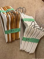 Bundles of natural and white wooden hangers taped in groups