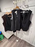 All four vests hanging, front view