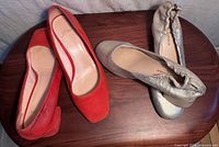 Both pairs of pumps on table—red J.Crew and gold Kelsi Dagger visible