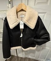 Front view showing black exterior, cream collar, tag attached