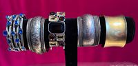 Front view of six cuff bracelets on display bar