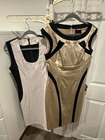 Both dresses on hangers showing front color-block designs