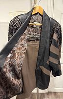 jacket on hanger open to show lining and skirt hanging beneath