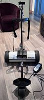 Full front view of electric golf caddy with battery, strap and charger visible
