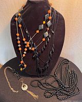 All four necklaces displayed together on bust and table