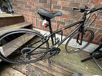 Left side view of Giant Transend bicycle showing full frame, drivetrain, wheels, saddle, lights, and lock