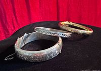Three vintage hinged bangles displayed together