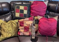 Five of the six pillows displayed on sofa plus warrior candle holder in foreground