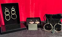 All three pairs of earrings in boxes and pouch