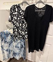 All three tops hanging: plaid shirt, abstract print blouse, black studded tunic