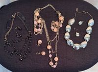 All three necklace and earring sets laid out