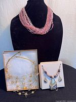 Group shot of all three necklaces and earring pair