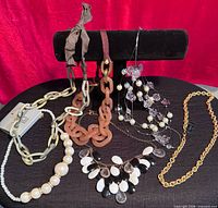 All eight necklaces displayed on stand