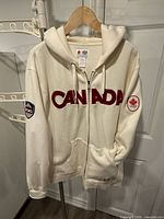 Front view showing CANADA lettering, zipper, pockets and both sleeve patches