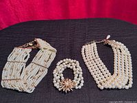 Group view of both chokers and bracelet on display surface