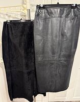 Two skirts hanging: leather on right, suede on left
