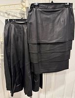 Both skirts side by side on hangers showing length difference and designs