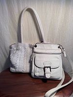 Both white purses side by side showing overall appearance and size comparison