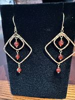 Front view of both earrings on display stand