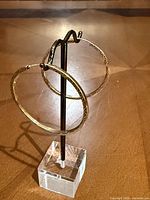 Both hoop earrings on display stand showing size and shape