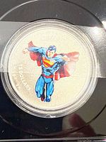 Coloured Superman coin in acrylic capsule within display