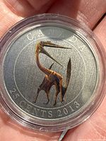 Obverse view of colourized Quetzalcoatlus coin in capsule