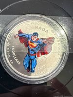 Obverse of colored Superman fine silver coin in capsule