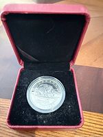 Coin in capsule inside black velvet-lined box
