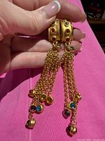 Full view of tassel clip-on earrings pair showing gold-tone metal, multicolored stones, chain tassels