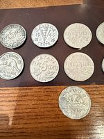 Group of nine coins, reverse side visible showing dates and designs