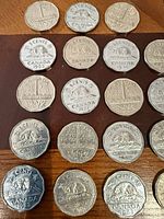 Multiple Canadian 5¢ coins laid out showing reverse beaver design and dates