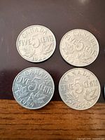 Four Canadian 5 cent coins showing dates 1922, 1928, 1929