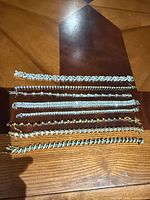 All eight bracelets laid out showing metal tones and stone colors