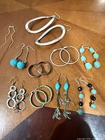 All nine pairs of earrings displayed on tabletop
