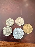 Obverse sides of all five coins and token arranged together