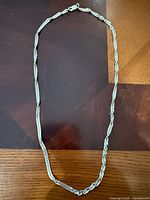 Full view of sterling silver chain laid flat showing overall style and length