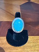 Front view of ring on stand showing turquoise cabochon and bezel